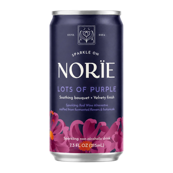 A 7.3 fl oz can of Nori’s 'Lots of Purple' sparkling non-alcoholic drink, featuring a deep navy blue label with purple floral graphics and white text, set against a plain white background.