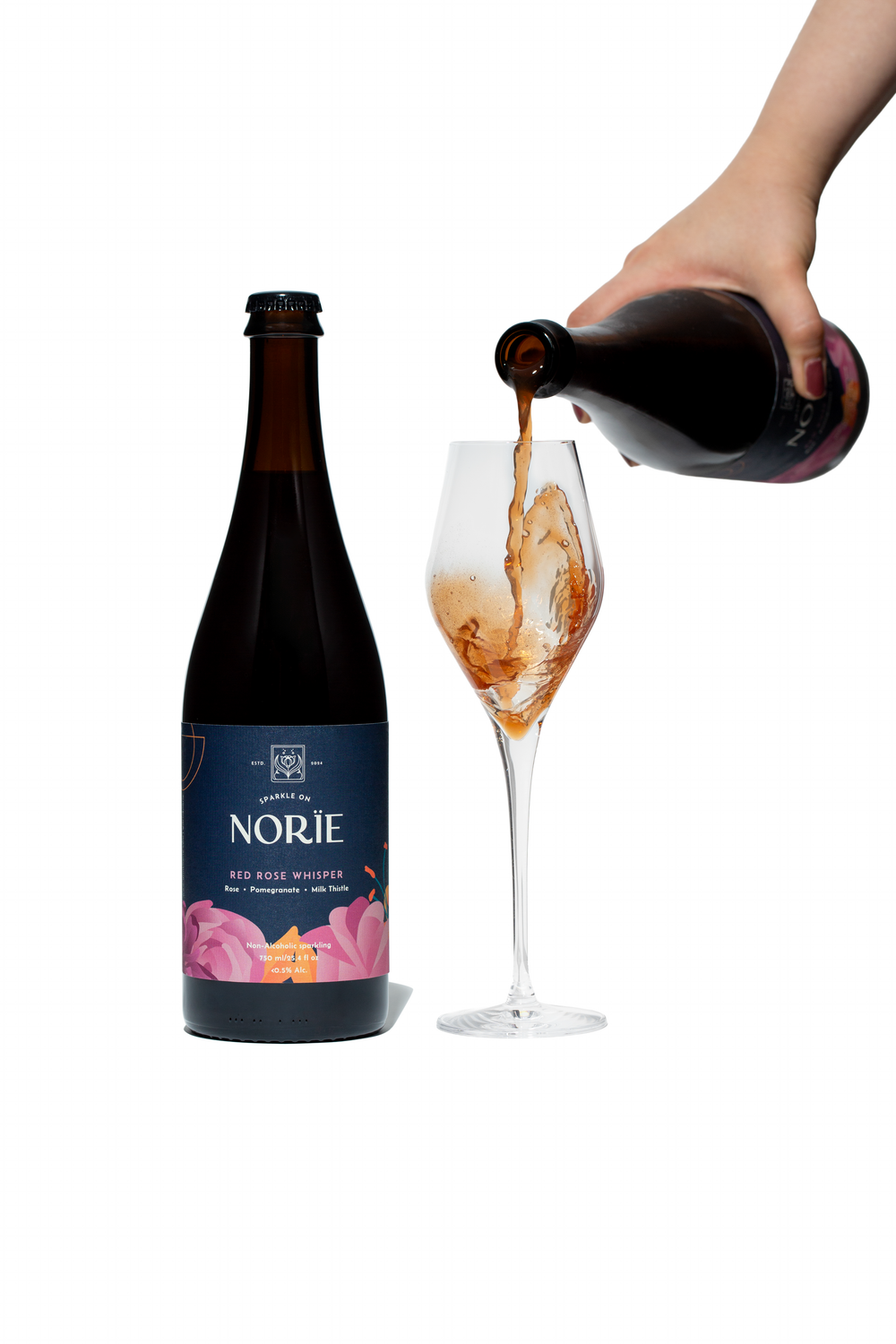 Bottle of Norïe Red Rose Whisper beside a glass as sparkling drink is poured